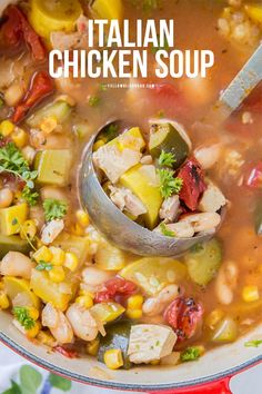 a red pot filled with chicken soup on top of a table