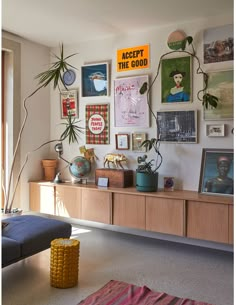 a living room filled with lots of pictures and plants