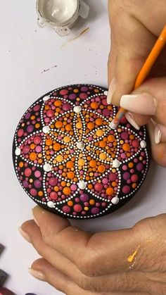 a woman is drawing on a rock with colored pencils