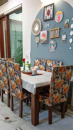 a dining room table and chairs with plates on the wall