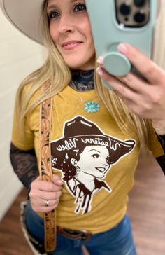 Texas True Threads Mustard Western Vibes Tee | Gussieduponline Saddle up for some serious style with our Mustard Western Vibes Tee! Featuring a vintage western graphic and playful wordplay, this cowgirl-approved tee is perfect for adding a bit of quirky charm to your wardrobe. From small businesses online boutique, this tee is a must-have for any western gal. Ride into style with our Mustard Western Vibes Tee! This quirky, vintage-inspired short sleeve tee features a vibrant mustard color and a Graphic Tees Western, Women's Western Wear, Vintage Western Style, Western Vibes, Western Boutique, Western Graphic Tees, Western Wear For Women, Graphic Tees Vintage, Wedge Heel Sandals