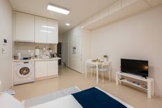 a kitchen and living room are separated by an open floor plan, with white cabinets