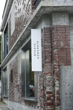 an old brick building with a sign hanging from it's side