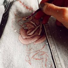 someone is using scissors to cut fabric on a piece of cloth that has been stitched together