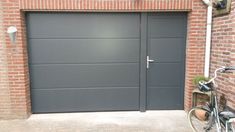 a bicycle is parked in front of a garage door with brick walls and doors on both sides