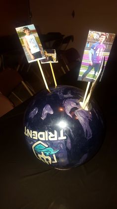 a bowling ball with pins sticking out of it sitting on top of a black table