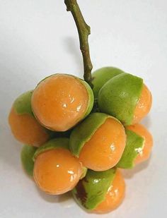 a bunch of fruit sitting on top of a white table next to a green leaf