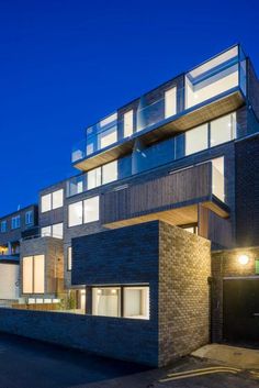 an apartment building lit up at night with lights on the windows and balconies