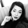 black and white photograph of a woman sitting on a couch with her hand under her chin