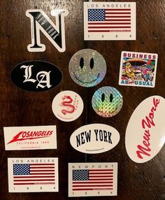 various stickers and decals on a wooden table with an american flag in the background