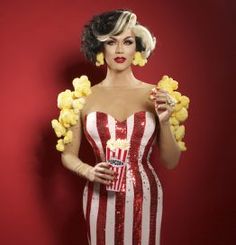 a woman in a red and white striped dress holding a popcorn bucket with yellow flowers around her neck