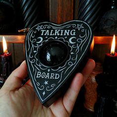 someone is holding up a black and white heart shaped object with the words talking board on it