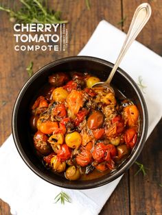 a bowl filled with lots of food on top of a wooden table next to a spoon