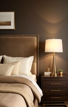 a bedroom with a bed, night stand and lamp on the bedside table next to it