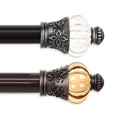 two black and gold colored decorative curtain rods with glass knobs on each rod ends