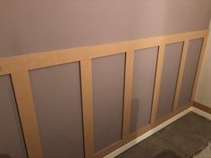 an empty room with wooden paneling on the wall and carpeted floor below it