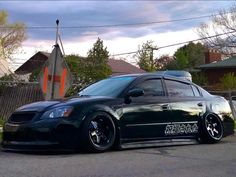 a black car parked in front of a house