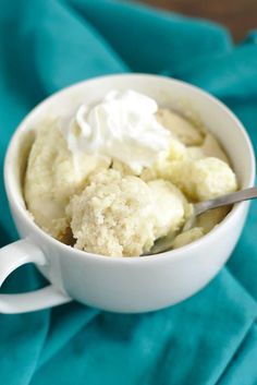 a white cup filled with ice cream on top of a blue cloth