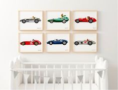 four framed photographs of classic race cars on a white wall above a crib in a baby's room