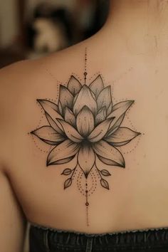 a woman's back with a lotus tattoo on it