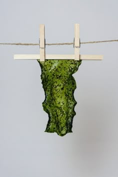 a piece of green material hanging from a clothes line