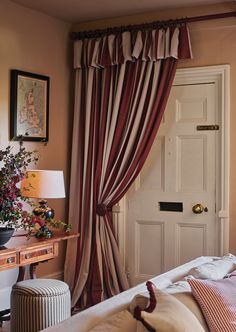 a bedroom with a white door and red curtains