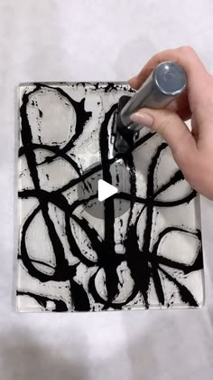 a person is using a pen to draw a black and white painting