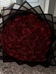 a bunch of red roses sitting on top of a counter