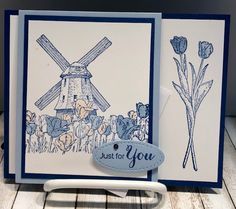 a close up of a greeting card with a windmill and flowers on the front side