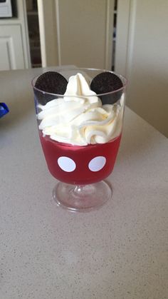 a red bowl filled with whipped cream and oreo cookies on top of a table