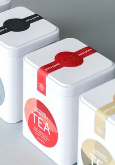 three tea tins with different designs on them