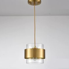 a gold and clear glass light fixture hanging from a ceiling in a room with white walls