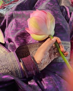 a woman is holding a flower in her hand