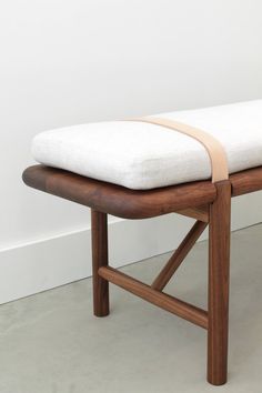 a wooden bench with a white cushion on it