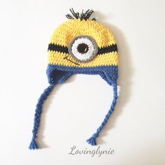 a crocheted yellow and blue hat with an evil eye on the front, made to look like a minion