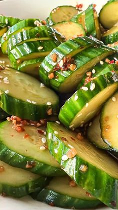 sliced cucumbers with sesame seeds and seasoning in a white bowl