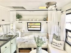 the interior of a tiny home with white furniture and decor on display in front of a window