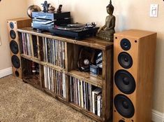 a record player is sitting on top of a bookcase with speakers and books in front of it