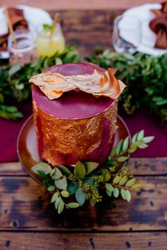 a cake sitting on top of a wooden table next to other plates and napkins