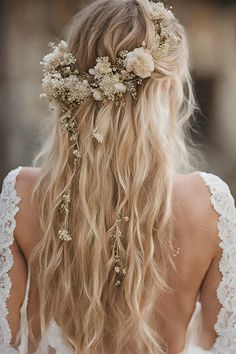 the back of a woman's head with long blonde hair and flowers in her hair