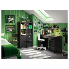 a bedroom with green walls and pictures on the wall, desk and chair in it