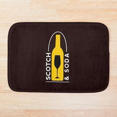 a black and yellow bath mat with a wine bottle on it that says, so do such