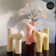 four vases with flowers in them sitting on a table next to each other,