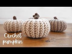 three knitted pumpkins sitting on top of a wooden table