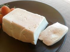 a black plate topped with tofu and carrots