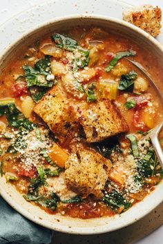 a bowl of soup with tofu and spinach