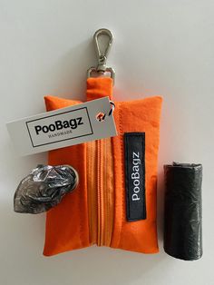 an orange zippered pouch with a tag attached to it