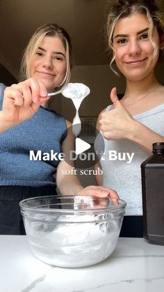 two women holding spoons in front of a mixing bowl