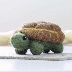 a small stuffed turtle sitting on top of a table