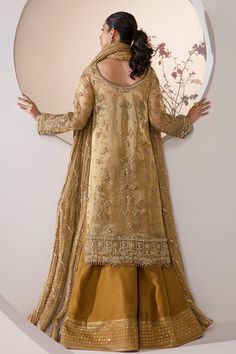 Embroidered Mustard Pakistani Wedding Dress in Kameez Gharara Style comes in Mustard and gold hues of this bridal making it a perfect option for a minimal barat look. The outfit is heavily embellished with zari, swarovski crystals, gota in bronze and gold hues. Paired with it is a crushed luxe organza dupatta with gota embellishments. The shirt is worn with sharara lined with mirror and threadwork at the border. The royal look of this bridal will bring attention to it at any event. Embroidered N Gold Floor-length Anarkali Set With Sheer Dupatta, Gold Floor-length Kurta With Sheer Dupatta, Elegant Palazzo Set With Gold Embroidery For Reception, Traditional Palazzo Set With Gold Embroidery For Reception, Gold Sharara With Sheer Dupatta In Raw Silk, Gold Raw Silk Sharara With Sheer Dupatta, Gold Salwar Kameez With Sheer Dupatta Floor-length, Traditional Gold Palazzo Set With Gold Embroidery, Gold Anarkali Kurta With Sheer Dupatta